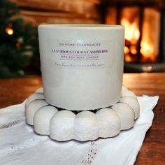 a white coffee cup sitting on top of a napkin next to a fire place holder