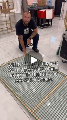 a man kneeling down on the ground with a metal grate