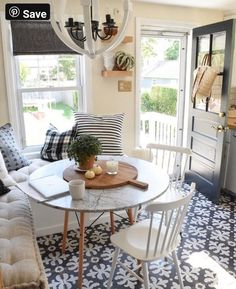 a living room filled with furniture and a white table in front of a window next to a couch