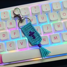 a keychain with a cross on it sitting in front of a keyboard