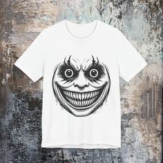 Darkness Grin Halloween. This striking "Darkness Grin" design is perfect for both men and women who appreciate bold and eerie aesthetics. Whether you're a fan of horror, a Halloween enthusiast, or someone who loves punk or streetwear fashion, this graphic tee captures the spirit of dark, edgy art. It's an ideal gift for anyone who enjoys the thrill of Halloween or loves to express their unique, spooky style year-round. Made for comfort and statement, this Halloween graphic T-shirt is sure to tur Carnage Birthday Shirt, Edgy Art, Spooky Style, Horror Lovers, Halloween Graphic, Streetwear Mode, Lovers Gift, Leisure Wear, Jersey Shorts