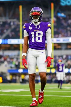 a football player is standing on the field with his helmet and gloves in hand,