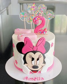 a minnie mouse birthday cake with lollipops in the shape of a number