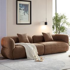 a living room with a large brown couch and white rug on the floor in front of a window