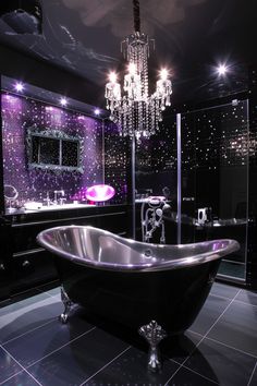 a bathroom with a tub and chandelier hanging from the ceiling in front of it