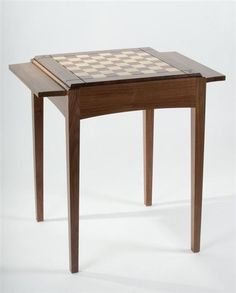 a wooden table with a chess board on it's top and one drawer open