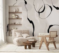 a living room with a chair, table and wall mural