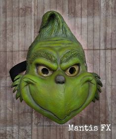 a green mask with an angry grin face on it's face and the words mantis fx above it