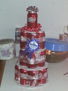 a stack of coca - cola cans stacked on top of each other with ribbons around them