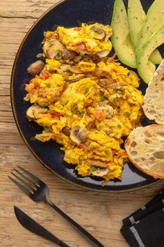 an omelet with mushrooms, bread and avocado on a blue plate