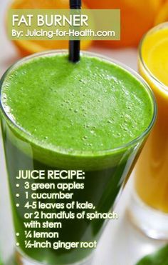 two glasses filled with green smoothie next to oranges