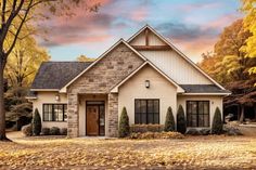 a house in the fall with leaves on the ground and autumn trees around it,