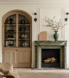 a living room filled with furniture and a fire place in front of a book case