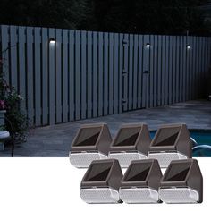 four lights are on the side of a fence near a pool and a house with a white picket fence