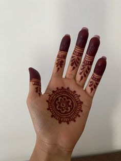 a woman's hand with henna tattoos on it