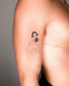 a woman's arm with a tattoo on it that has an image of a woman holding a baby