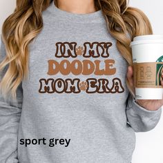 Celebrate your Doodle Mom status with our "In My Doodle Mom Era" sweatshirt. This comfy, stylish sweatshirt is a must-have for all Doodle enthusiasts. 🐾 Cozy and Stylish: Made with a blend of soft cotton and polyester, this sweatshirt keeps you warm and comfortable while showcasing your love for Doodles. 🐾 Unique Design: The "In My Doodle Mom Era" graphic is a playful way to express your affection for your Doodle companion. 🐾 Ideal Gift: Looking for a thoughtful present? This sweatshirt is pe Mom Status, Mom Crewneck, Doodle Mom, You Doodle, Mom Sweater, Mom Era, Golden Doodle, Labradoodle, Mom Shirt