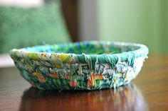 a close up of a bowl on a table with a chair in the back ground