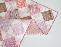 two pink and white quilts on top of each other