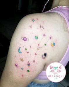 the back of a woman's shoulder with stars and planets on her left side