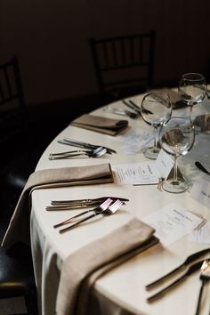 the table is set with silverware and place settings