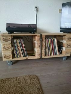 an entertainment center made out of wooden pallets with cd's on the wheels