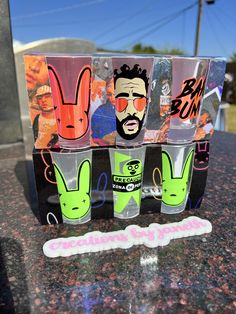 the shot glasses have been decorated with cartoon characters and are sitting on top of a granite table