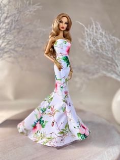 a barbie doll wearing a white floral dress