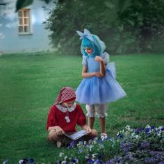 two children dressed up in costumes are sitting on the grass and looking at an open book