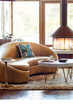 a living room filled with furniture and a fire place in the middle of the room