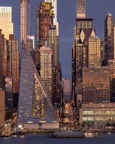 the city skyline is lit up at night, with skyscrapers in the foreground