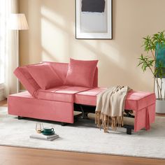 a living room scene with focus on the pink couch and ottoman in the foreground