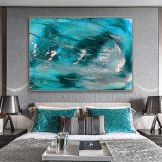 a large painting hanging above a bed in a room with two lamps on either side of the bed