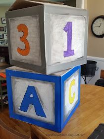 two blocks that have numbers on them sitting on top of a table in front of a clock