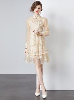 Majestic in its design, this tiered dress exudes a vintage charm that's perfect for the modern romantic. Crafted from layers of delicate, gossamer-like fabric, each tier is sprinkled with an array of floral embellishments that gleam subtly, reflecting the light with every movement. The high collar adds a touch of demure sophistication, while the full-length sleeves provide an elegant silhouette. This dress cinches at the waist, featuring a self-tie ribbon that allows for a customizable fit, enha Elegant Tiered Dress With Lace Trim, Elegant Embellished Tiered Skirt Dress, Spring Organza Dress With Lace Trim, Spring Tiered Organza Dresses, Elegant Tiered Lace Dress With Lace Patchwork, Elegant Tiered Lace Dress With Patchwork, Feminine Tiered Lace Dress, Embellished Party Dress With Tiered Skirt, Embellished Tiered Skirt Party Dress