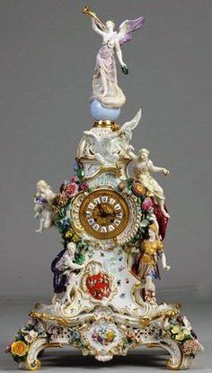 an ornate clock with angel figurines on it's top and bottom part