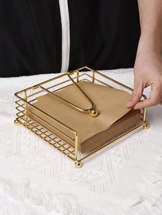 a person holding a binder over a stack of books on top of a table