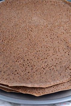 two tortillas sitting on top of each other on a blue plate with white cloth