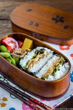 a bento box filled with sushi and vegetables