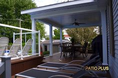 a deck with lounge chairs on it and a table in the back ground next to it