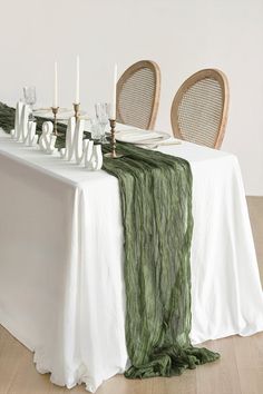 the table is set with white and green linens, candles, and napkins