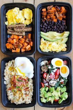 four black trays filled with different types of food on top of a wooden table