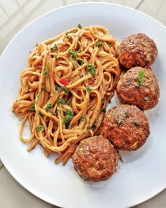 spaghetti and meatballs on a white plate