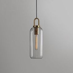 a glass and brass pendant light hanging from a ceiling