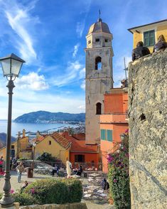 a clock tower towering over a city next to a body of water