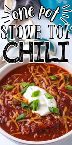 a white bowl filled with chili and topped with sour cream