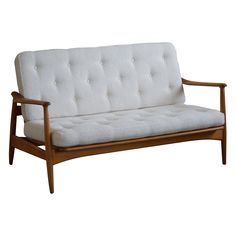 a white couch sitting on top of a wooden frame