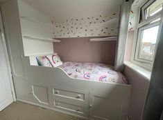 a bedroom with a bunk bed in the corner and a window on the other side