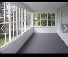 an empty room with white walls and windows