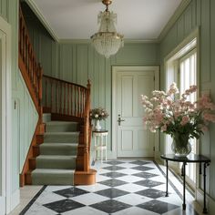 a room with green walls and checkered flooring next to a chandelier